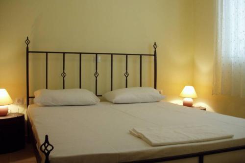 sypialnia z łóżkiem z 2 poduszkami i 2 lampami w obiekcie Cephalonia Sami, luxury apartment. w mieście Sami