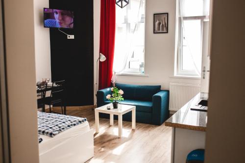 ein Wohnzimmer mit einem Sofa und einem Tisch in der Unterkunft SouvenirAppart Wilenska in Bydgoszcz