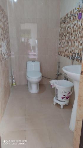 a bathroom with a white toilet and a sink at CITY CROWN GUEST HOUSE in Sundarnagar