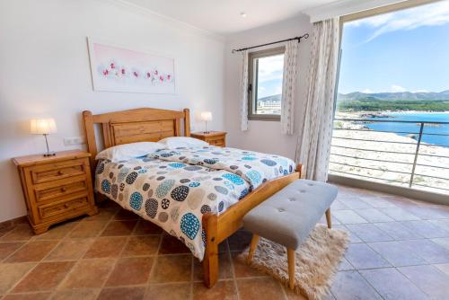 a bedroom with a bed and a large window at Cala Agulla 1 in Cala Ratjada