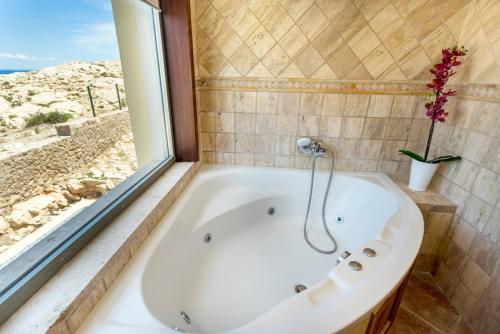 a bath tub in a bathroom with a window at Cala Agulla 1 in Cala Ratjada