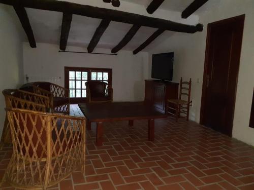 ein Wohnzimmer mit einem Tisch und einem TV in der Unterkunft Molí dels Aubins in Cornudella de Montsant