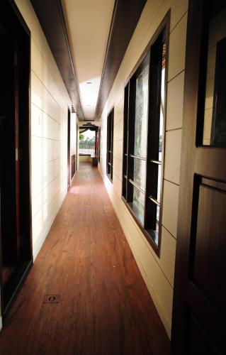 a hallway of a building with a wooden floor and windows at Vaishnav Tours in Alleppey
