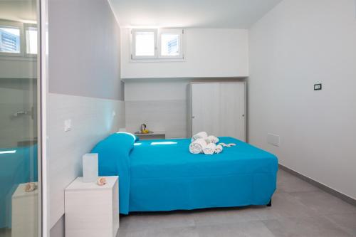 a room with a blue couch with two stuffed animals on it at Residenziale Blu 1 in Marina di Pescoluse