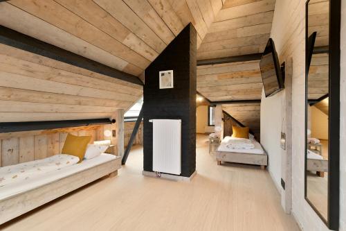 - une chambre avec 2 lits dans une chambre dotée de plafonds en bois dans l'établissement Villa Miro, à Saint-Idesbald
