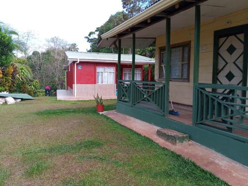 ein Haus mit einer grünen Veranda und einem roten Gebäude in der Unterkunft Casa Los Ángeles in Ángeles