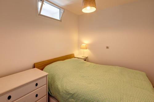 um quarto com uma cama, uma cómoda e uma janela em Cabanon de Malmousque em Marselha