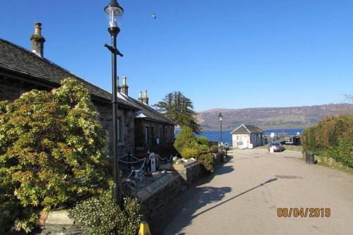 a street light in front of a building next to the water at Craiglynn Holiday Apartment Loch Lomond in Balloch