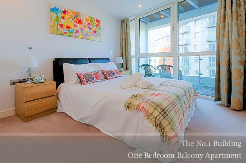 a bedroom with a large bed with a window at Gunwharf Quays Apartments in Portsmouth