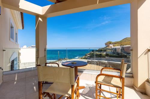 a balcony with a table and chairs and a view of the ocean at Villa Andreas in Panormos Rethymno