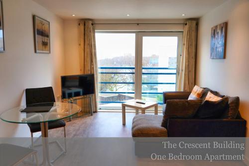 a living room with a couch and a glass table at Gunwharf Quays Apartments in Portsmouth