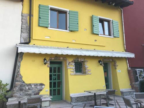 a yellow building with green doors and windows at Borgo Piccolo in Cavaion Veronese