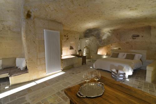 a bedroom with a bed and a table in a room at Grotta Gea Luxury Home con Piscina & Spa in Matera