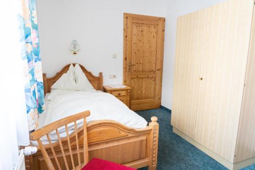 a bedroom with a wooden bed and a wooden cabinet at Gasthof Diewald in Raach am Hochgebirge