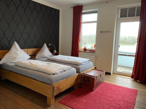 two beds in a room with a red rug at Kanal 33 in Schafstedt