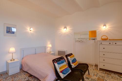 - une chambre avec un lit, une commode et deux chaises dans l'établissement Le petit Malmousque, à Marseille