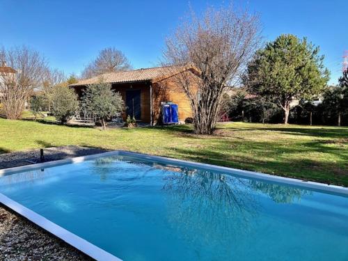 a large blue swimming pool in front of a house at Crisalys Chambres d'Hôtes in Pessac