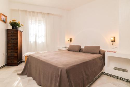 een slaapkamer met een bed, een dressoir en een raam bij Aldea del Mar in Torrevieja