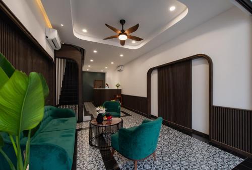 a lobby with green chairs and a ceiling fan at Khách sạn gần biển Miami Tuy Hoà Phú Yên in Liên Trì (3)