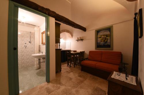 a living room with a couch and a bathroom at Trulli La Zisa in Fasano