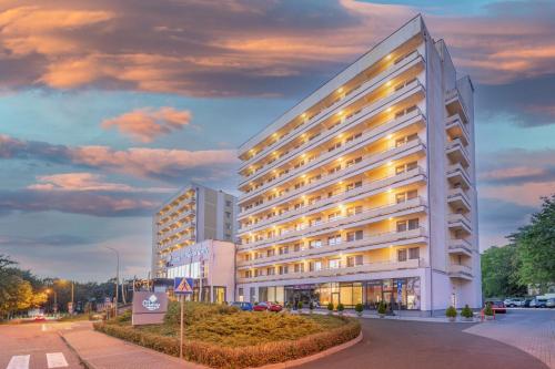duży biały budynek z oświetleniem w obiekcie Vestina Wellness & SPA Hotel w mieście Międzyzdroje