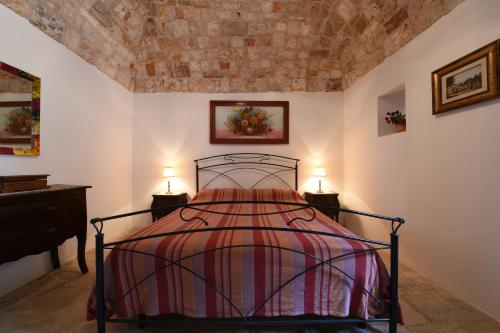 a bedroom with a bed and two lamps on tables at Trulli La Zisa in Fasano