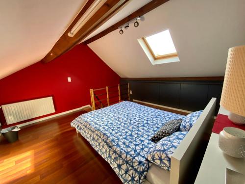 a bedroom with a bed and a red wall at Grand Appartement Jourdan EU in Brussels