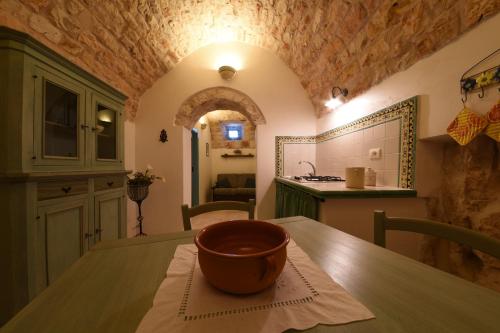 a kitchen with a wooden table with a bowl on it at Trulli La Zisa in Fasano