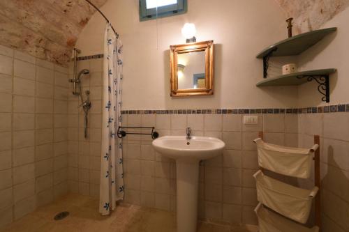 a bathroom with a sink and a shower at Trulli La Zisa in Fasano