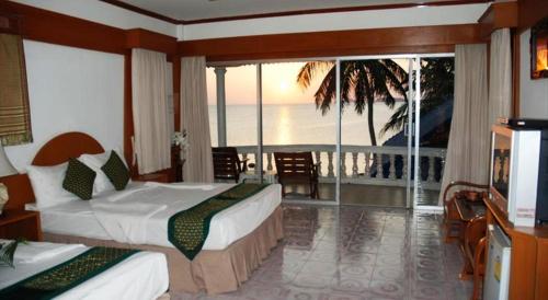 a hotel room with two beds and a view of the ocean at Phangan Sunset Resort in Baan Tai