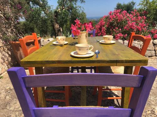 a wooden table with cups and saucers on it at Trulli La Zisa in Fasano