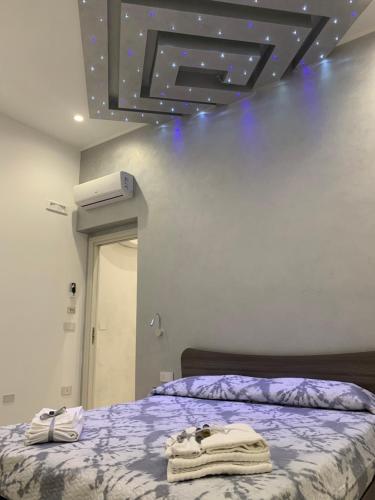 um quarto com uma cama com lençóis roxos e um tecto em B&B Vittorio Emanuele em Licata