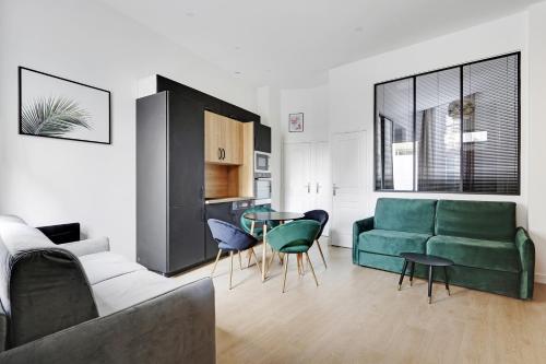 a living room with a couch and a table and chairs at Majesti apartment in Marais - Rue du Petit Musc in Paris