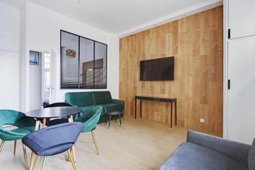 - un salon avec des chaises vertes et une table dans l'établissement Majesti apartment in Marais - Rue du Petit Musc, à Paris