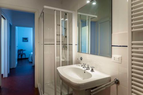 ein weißes Badezimmer mit Waschbecken und Dusche in der Unterkunft Maranghetto appartamenti in Caorle