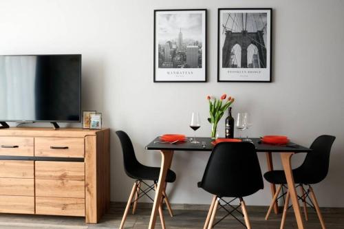 a dining room with a table with chairs and a tv at EASY RENT Apartments - Crystal, Basen & SPA, Centrum, 24h Check-in in Lublin