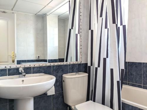 łazienka z umywalką, toaletą i lustrem w obiekcie Cabeho Beach Homes w mieście Calpe