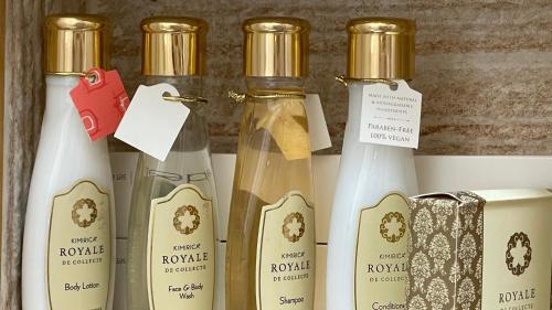 a group of four bottles of perfume on a shelf at Fort Guesthouse نُزل القلعة in Muscat