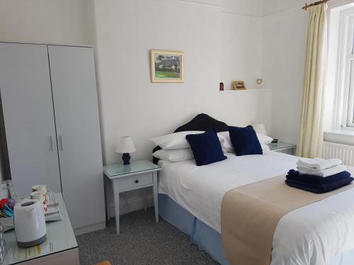 a bedroom with two beds with blue pillows at Montrose Guest House in Minehead