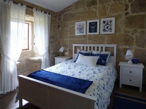 a bedroom with a bed and a stone wall at CASA VEIGA in Pontevedra