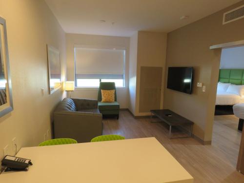 a small living room with a couch and a tv at Wyndham Garden College Station in College Station