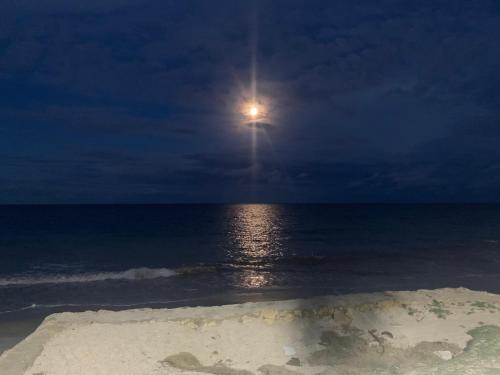 a full moon over the ocean at night at Casa de Praia Pitimbu in Pitimbu