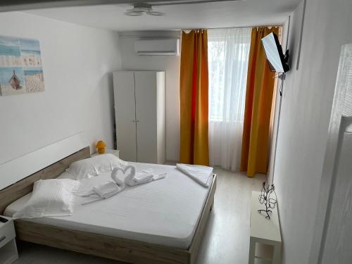 a bedroom with a white bed with towels on it at Apartament Olimp in Olimp