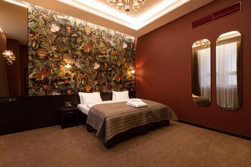 a bedroom with a large painting on the wall at Tsunami Spa Hotel in Dnipro