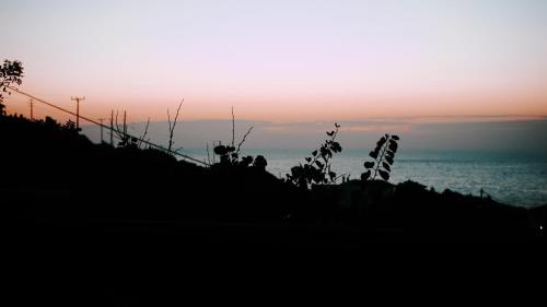 a silhouette of a sunset over the ocean at Pension Galini in Armenistis