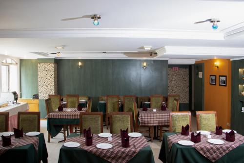 a conference room with tables and chairs and a chalkboard at Alpine Continental in Shillong