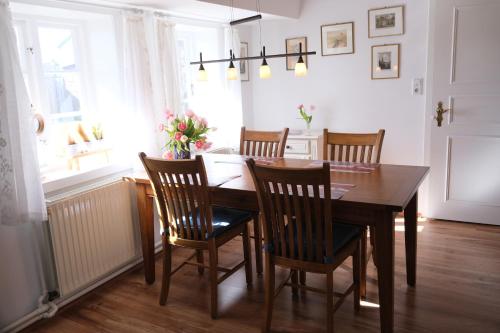a dining room with a wooden table and chairs at Haus-an-de-Marsch in Midlum