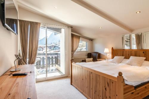 a bedroom with a large bed and a large window at SCHUSS D4 in Morzine