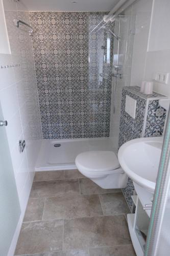 a bathroom with a toilet and a sink and a shower at Haus-an-de-Marsch in Midlum