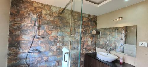 a bathroom with a sink and a glass shower at The Periaheights in Periya